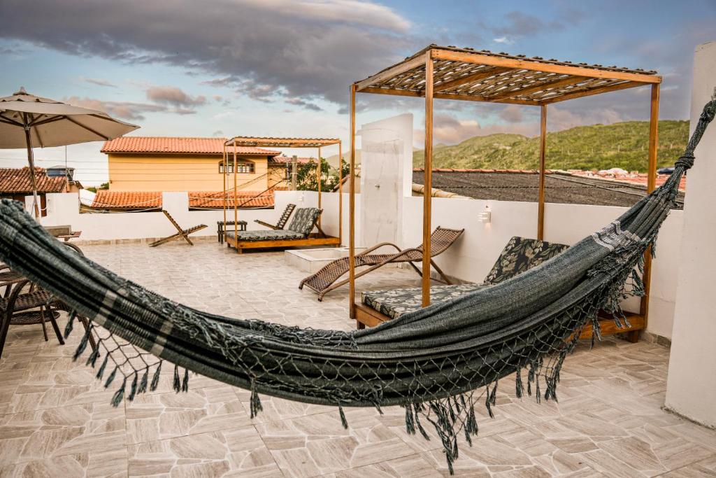 a hammock on the roof of a house with a view at Pousada do Trovão - Melhor localização de Arraial in Arraial do Cabo