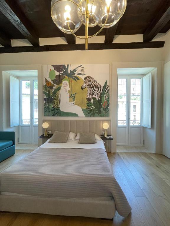 a bedroom with a large bed and a chandelier at Ellebi Galleria e Dimora D'arte in Cosenza