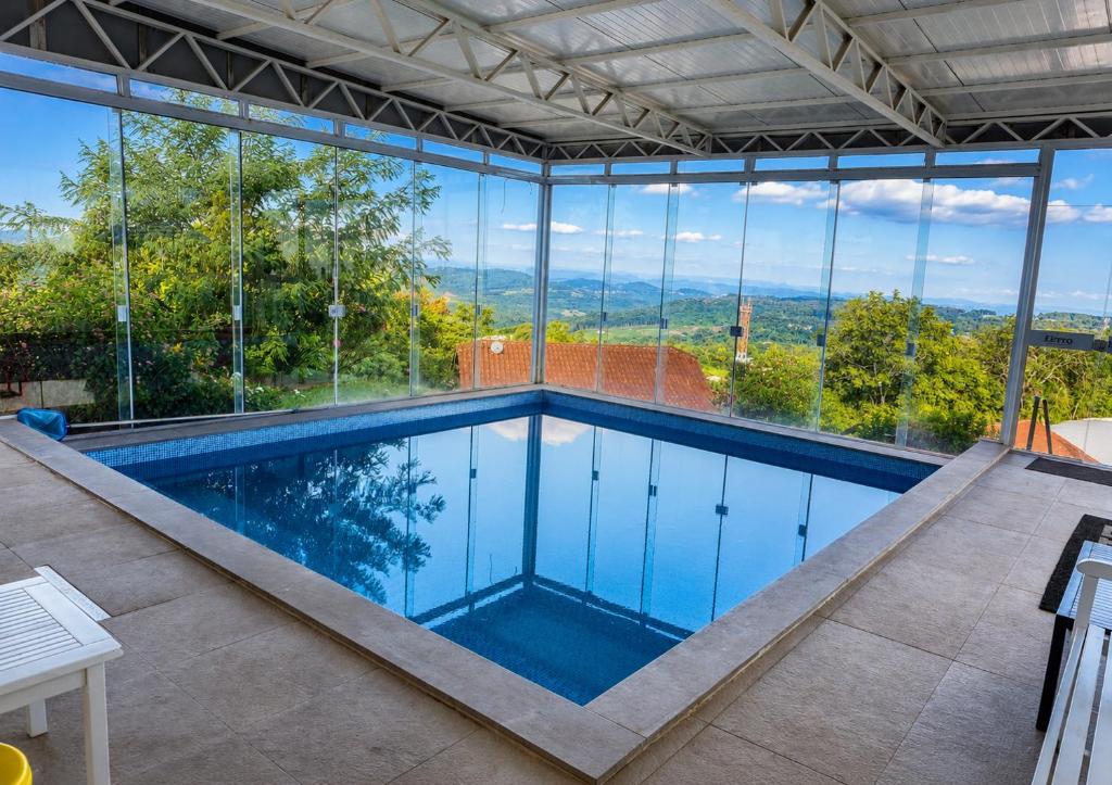 a swimming pool in a house with large windows at Letto Hotel Candeeiro da Serra in São Salvador