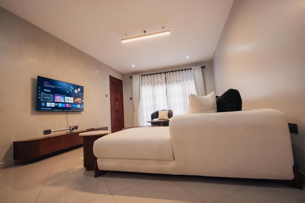 a bedroom with a large white bed and a couch at Smart Luxury Apartment, Bunga in Kampala