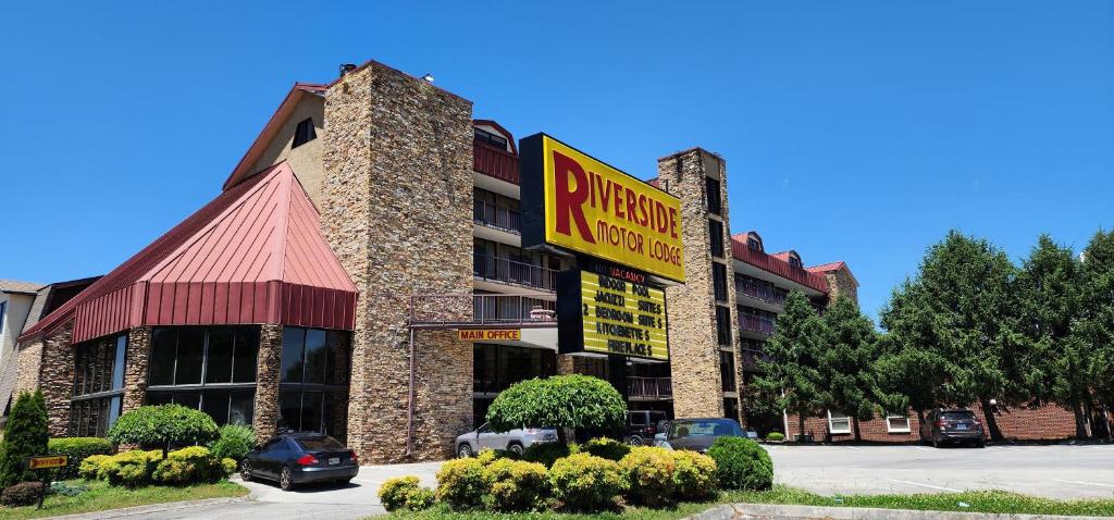a hotel building with a sign for a pizzeria at Riverside Motor Lodge - Pigeon Forge in Pigeon Forge