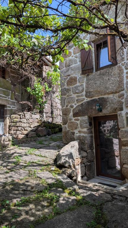 a stone building with a door and a window at Casa D'Zelo - Gerês in Montalegre