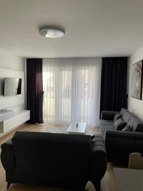 a living room with a couch and a table at Adora's Apartment in Peje