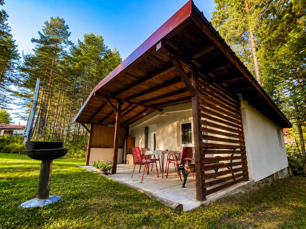 a house with a patio with red chairs and a grill at Vikendica Stari Grad in Divčibare
