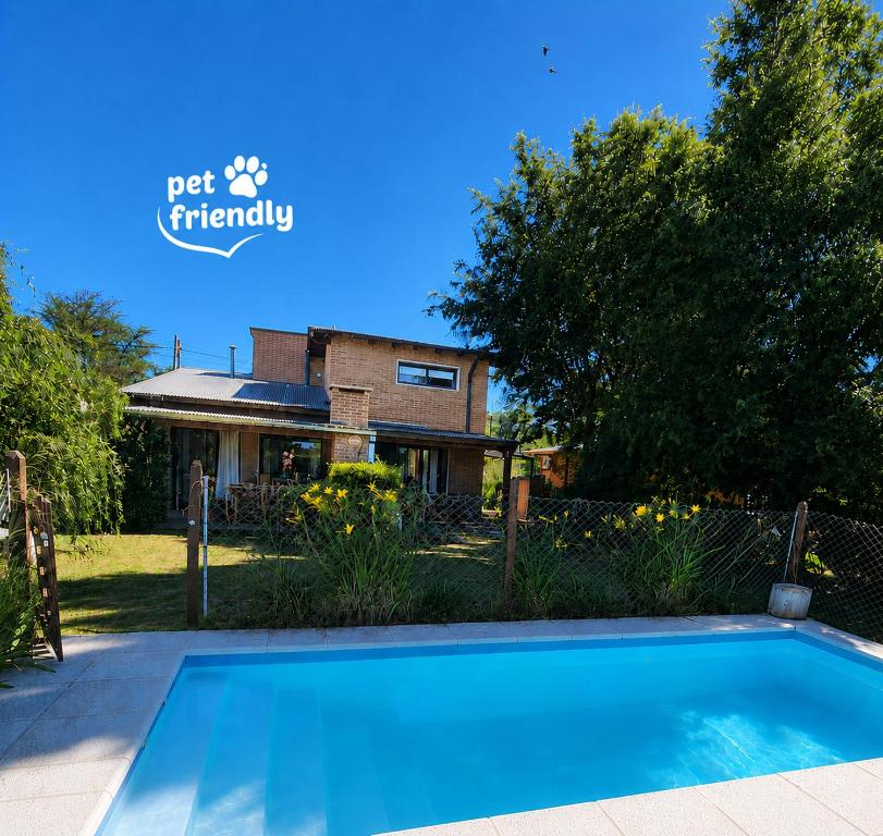 a swimming pool in front of a house at Atardecer Serrano in Villa General Belgrano