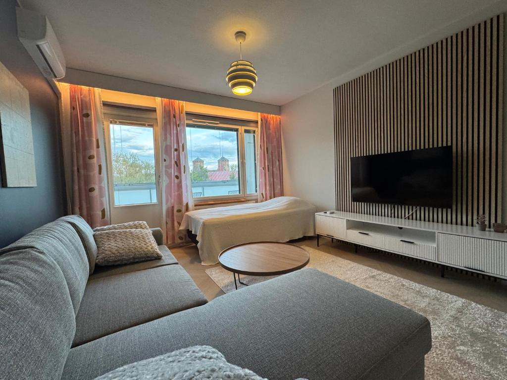 a living room with a couch and a tv at Opera Magic Castle View, Air-Con, Free wifi in Savonlinna