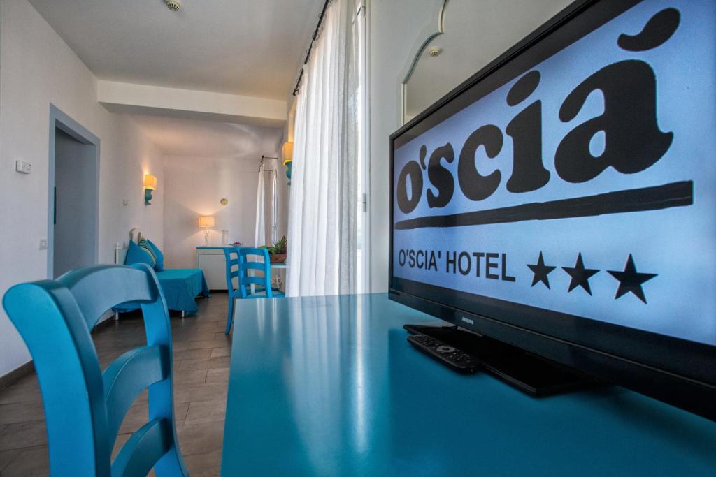 a tv sitting on a table in a room with blue chairs at Hotel O'scià in Lampedusa