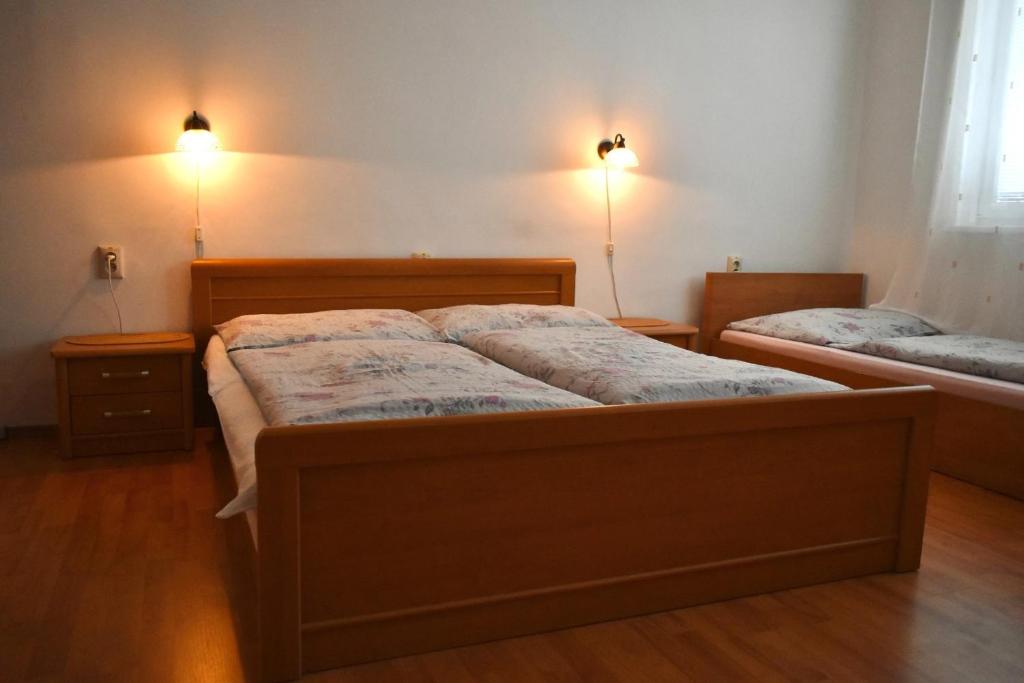 a bedroom with two beds and two lights on the wall at Villa Paris in Piešťany