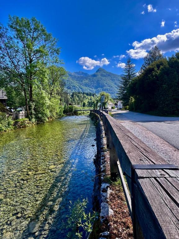 a river next to a road and a bridge at The Yugo House in Bohinj