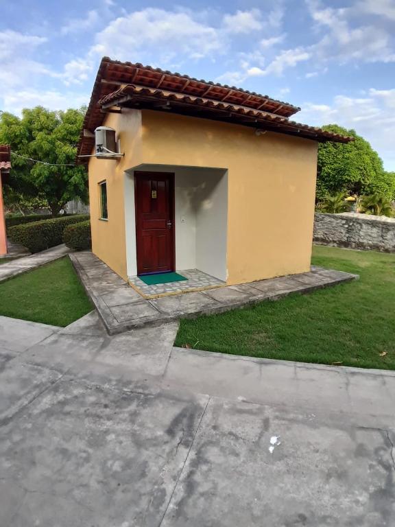 a small house with a red door in a yard at Torre do Sol Park Hotel in Chapadinha
