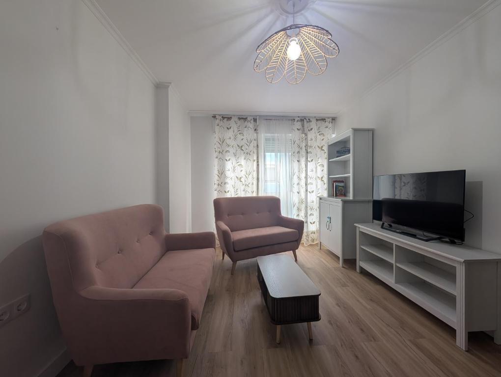 a living room with a couch and a tv at Mosquera House in Arzúa