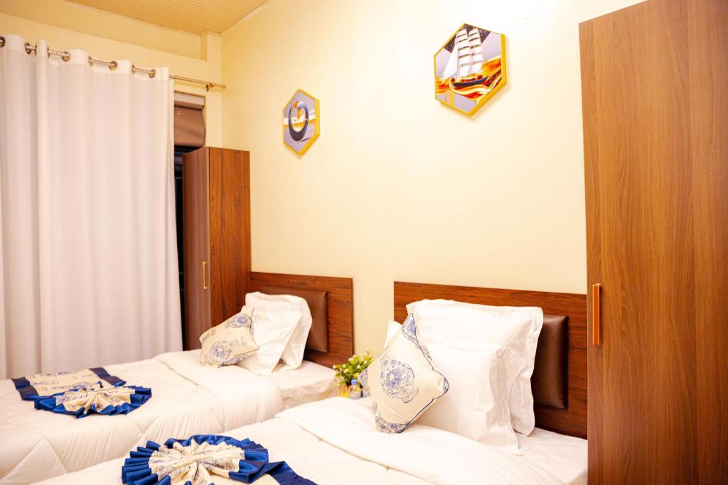 a bedroom with two beds with white sheets at Lemon hills hotel in Runda