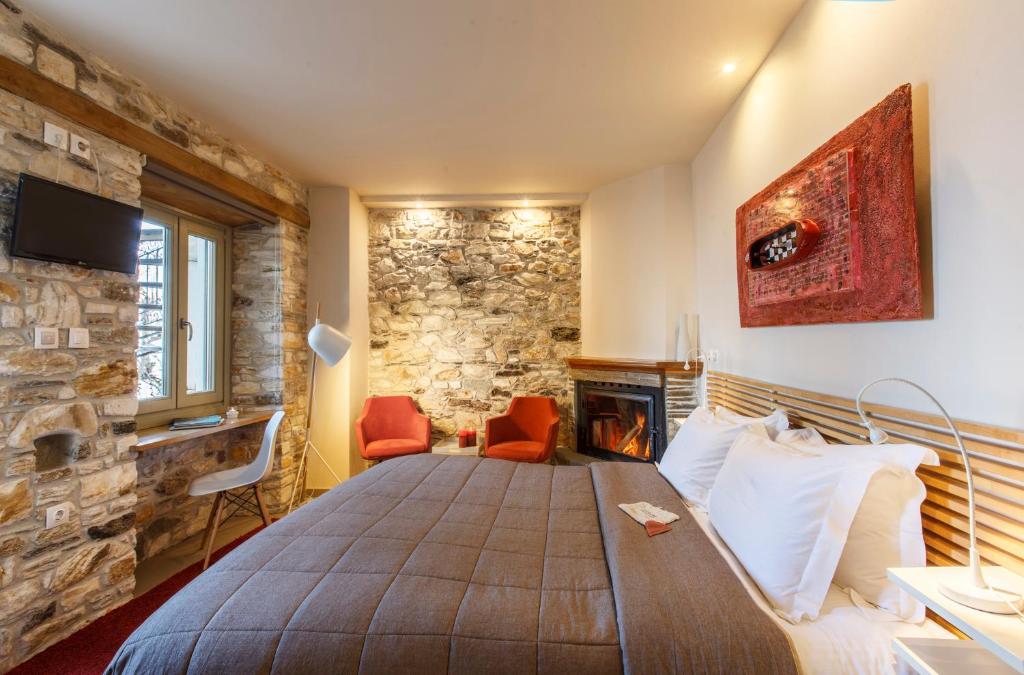 a bedroom with a large bed and a stone wall at Olga in Mouresi