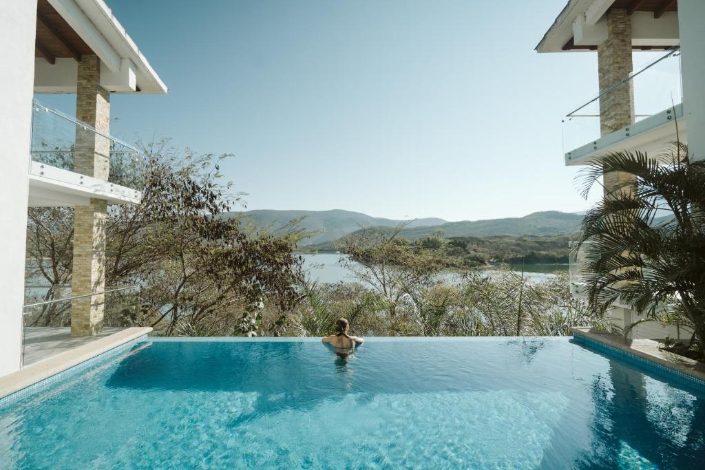 a person in a swimming pool with a view of the water at Casa de Lago in Jalpan de Serra