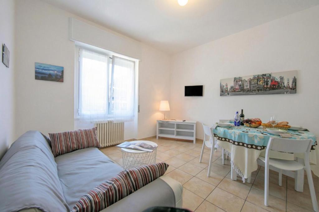 a living room with a couch and a table at Casa Al Caprifoglio - Ispra Apartment 600m From Beach - Happy Rentals in Ispra