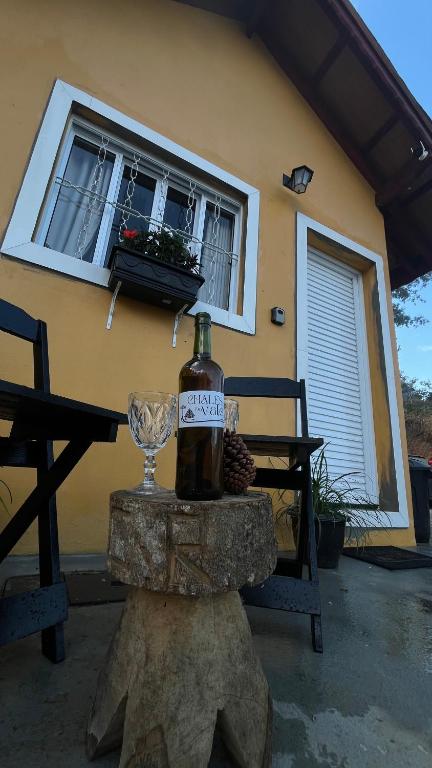 a bottle of wine and a glass on a table at Chale Amarelo Aconchegante com lareira no bosque e estacionamento grátis in Extrema