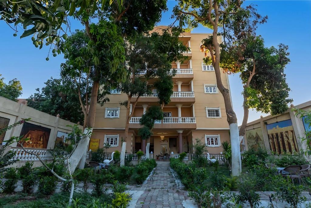 a building with trees in front of it at El Agamy Hotel Apartment in Luxor
