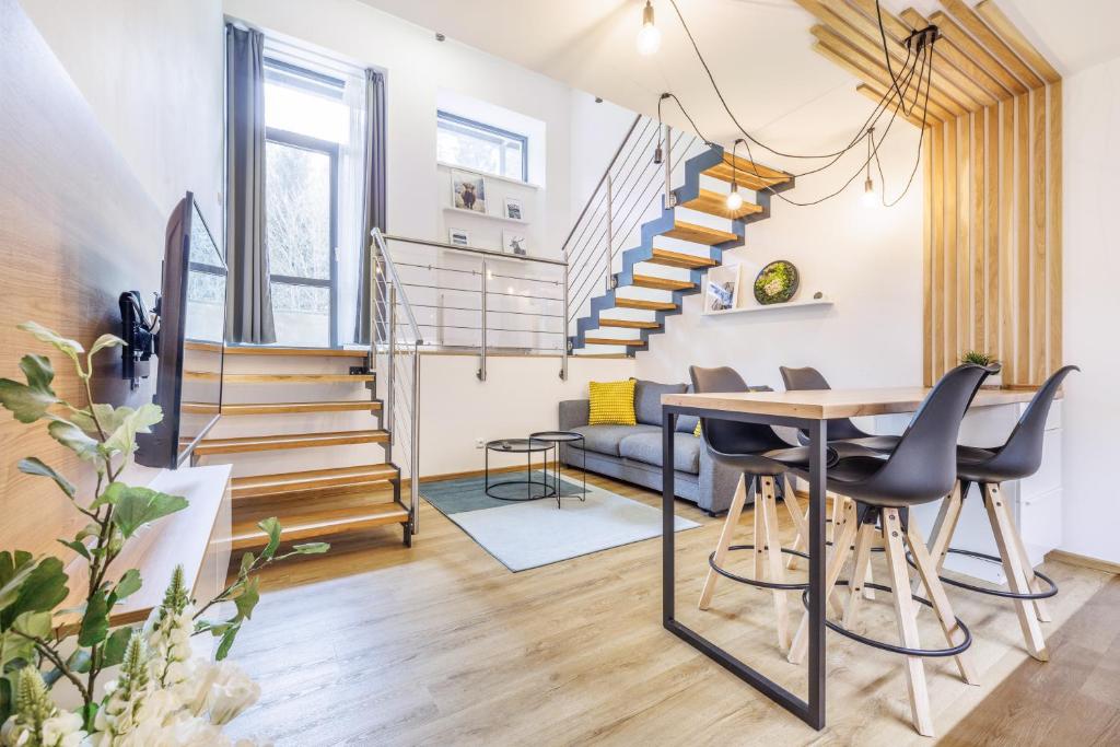 a living room with a table and chairs and stairs at Jasmínový Ráj in Vítkovice