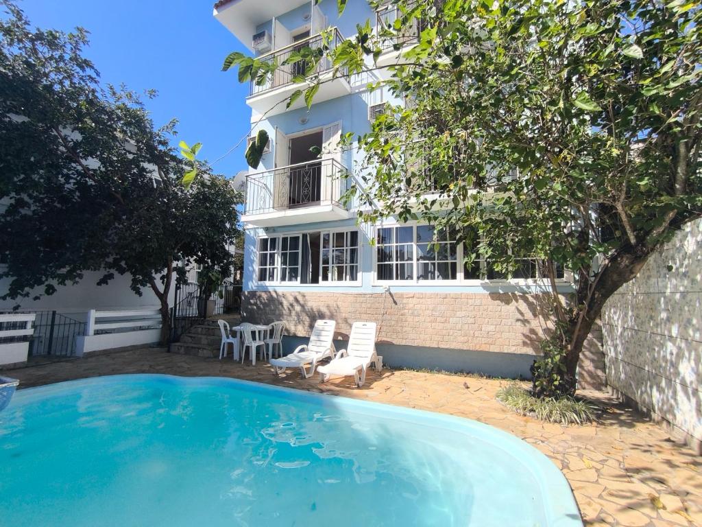 a house with a swimming pool in front of a building at "Cantinho das serestas" em flats com piscina, sem café in Conservatória