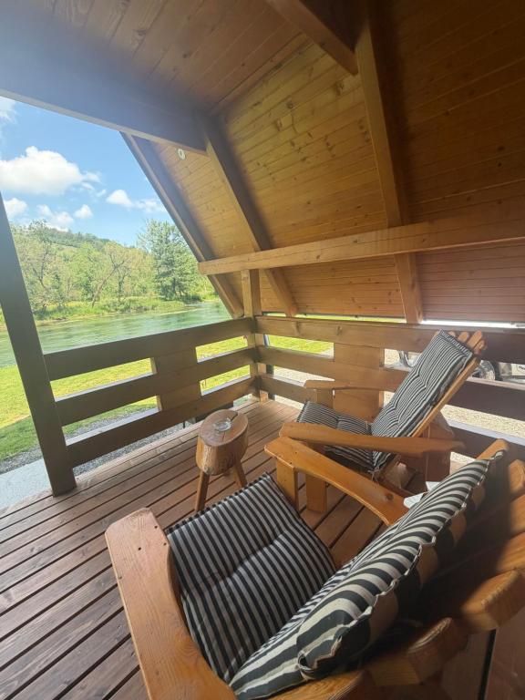 a wooden cabin with a bench and a chair on a deck at Bungalow Jajce 1 Cottage in Jezero