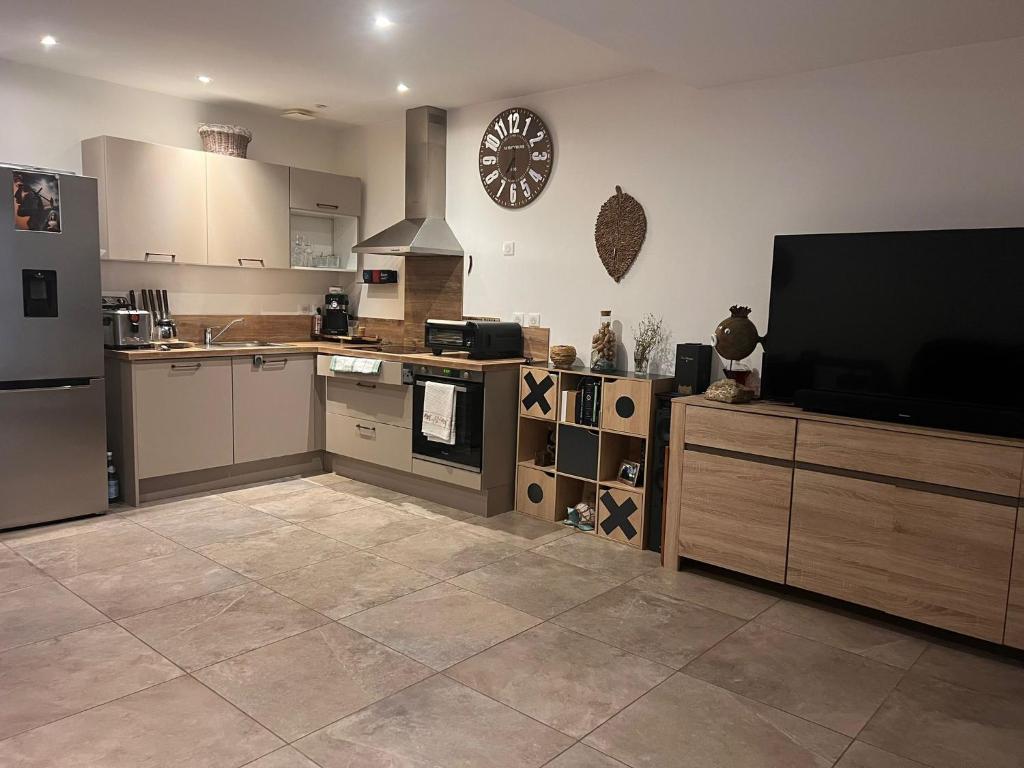 a kitchen with a television and a kitchen with a clock on the wall at F3 CENTRE de ST-FLORENT in Saint-Florent