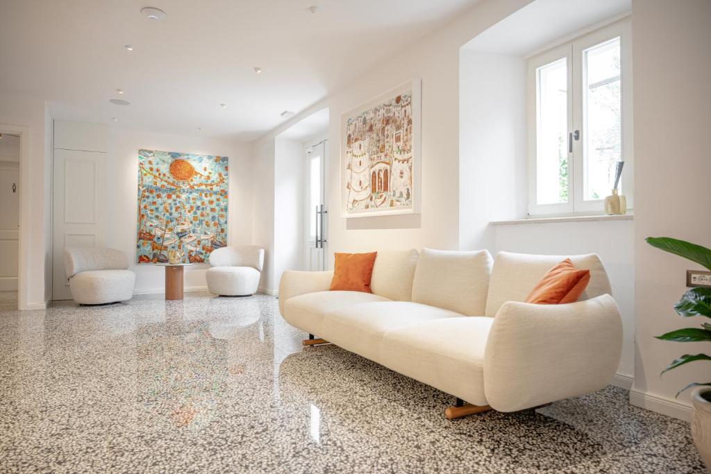 a living room with a white couch and a painting at Heritage Hotel Lucia in Dubrovnik