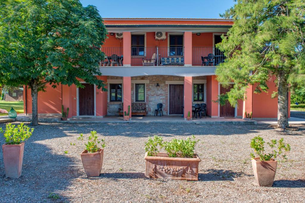 an orange house with trees in front of it at Capracotta in Montemassi