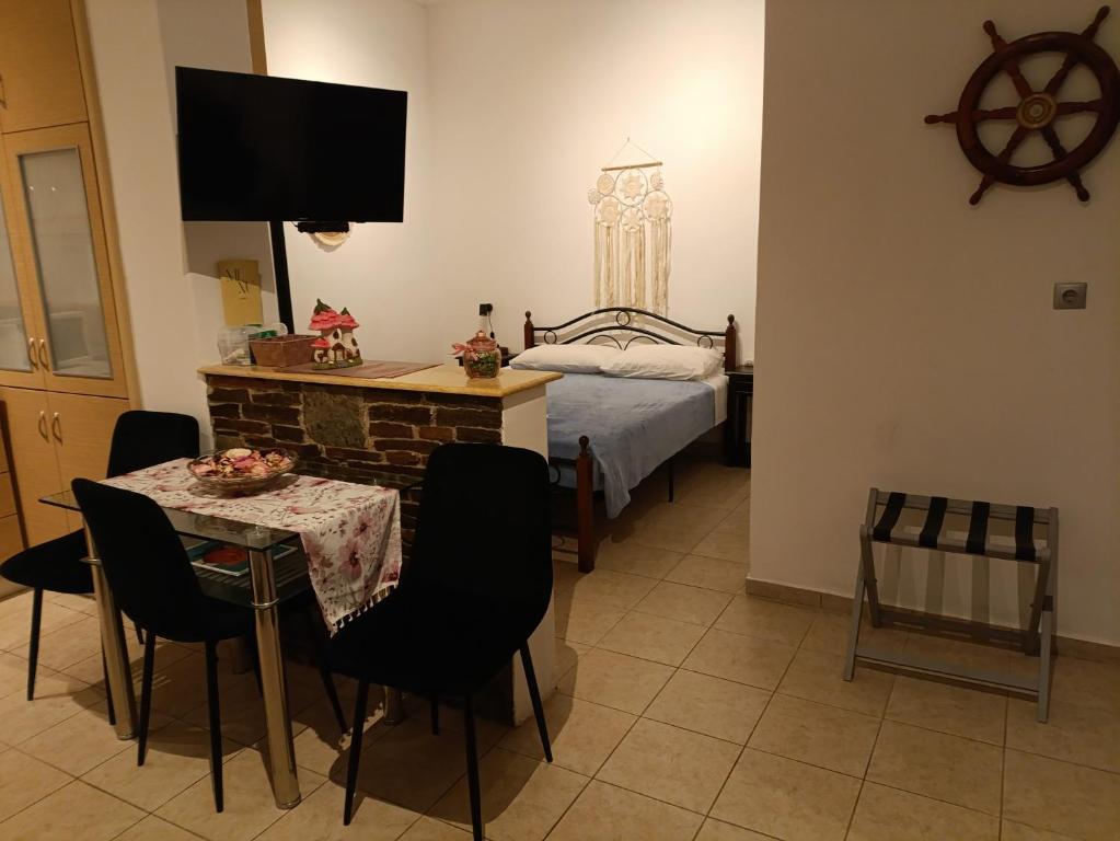 a room with a bed and a table with chairs at Gorgona 1 in Loutra
