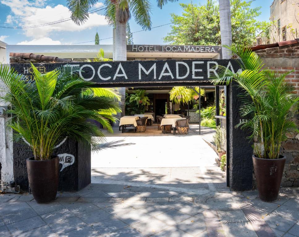 a sign for a taco market with palm trees in front at Toca Madera in Chapala