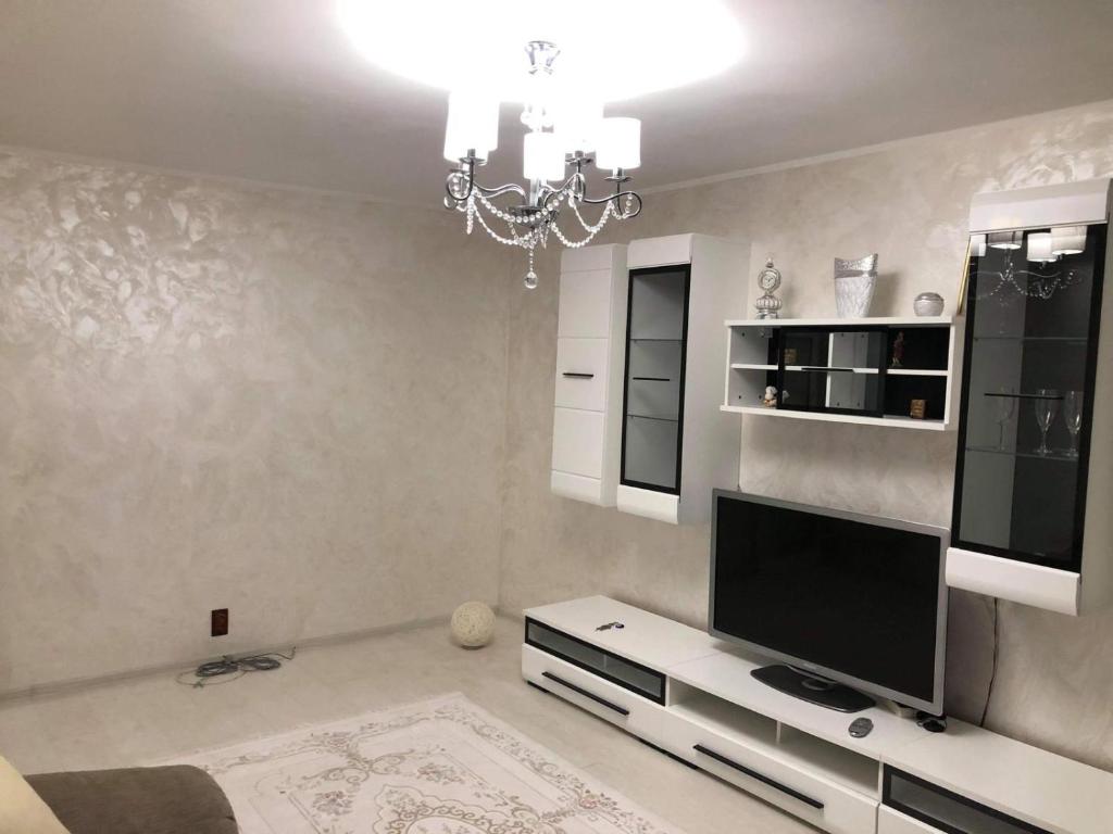 a living room with a television and a chandelier at AmiraHome in Galaţi