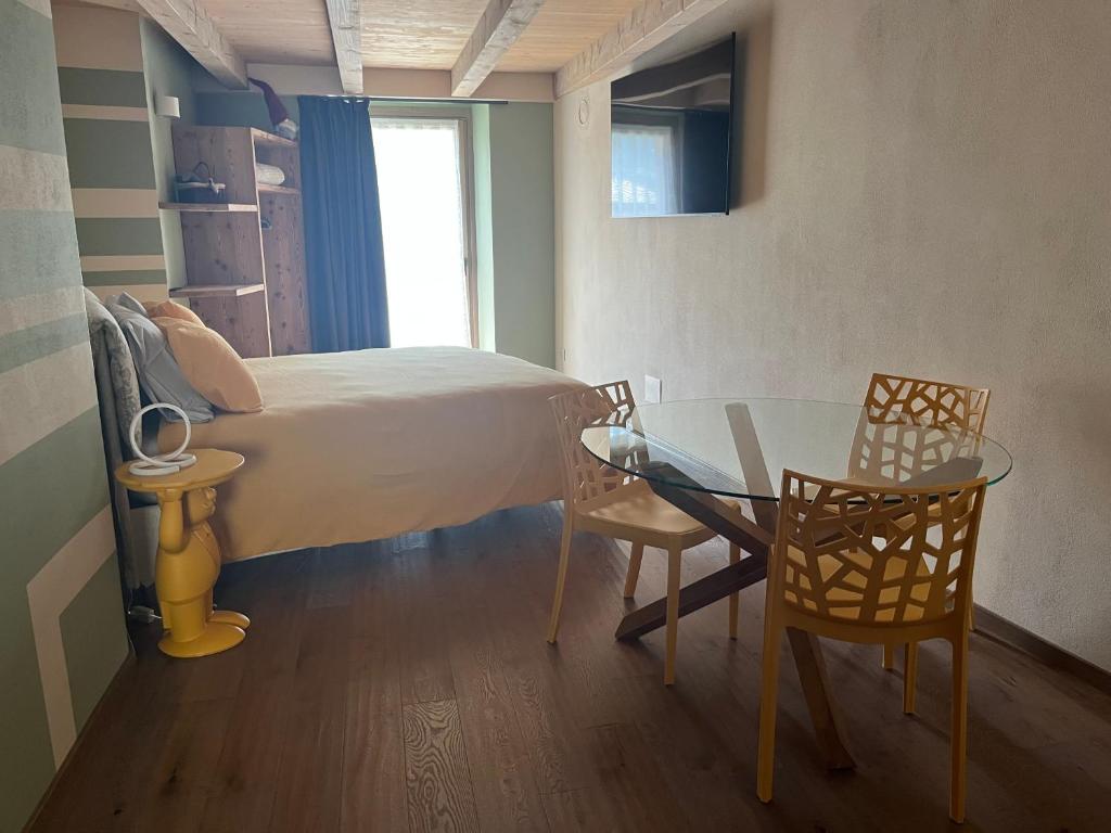 a bedroom with a bed and a table and chairs at La Crevasse Morgex in Morgex