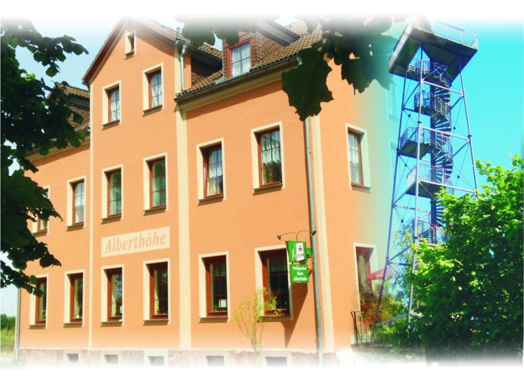 ein großes orangenes Gebäude mit einem Schild drauf in der Unterkunft Waldgasthof & Hotel Alberthöhe in Lichtenstein