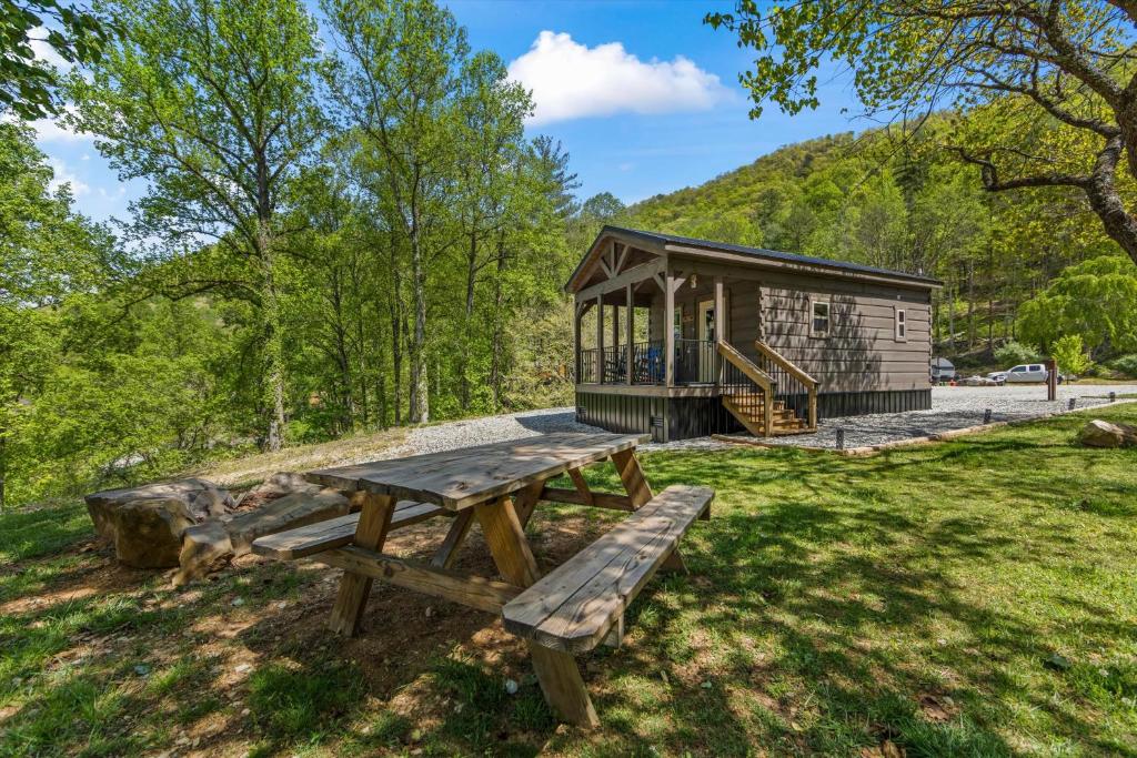 a picnic table and bench in front of a cabin at Nantahala Ridge in Bryson City