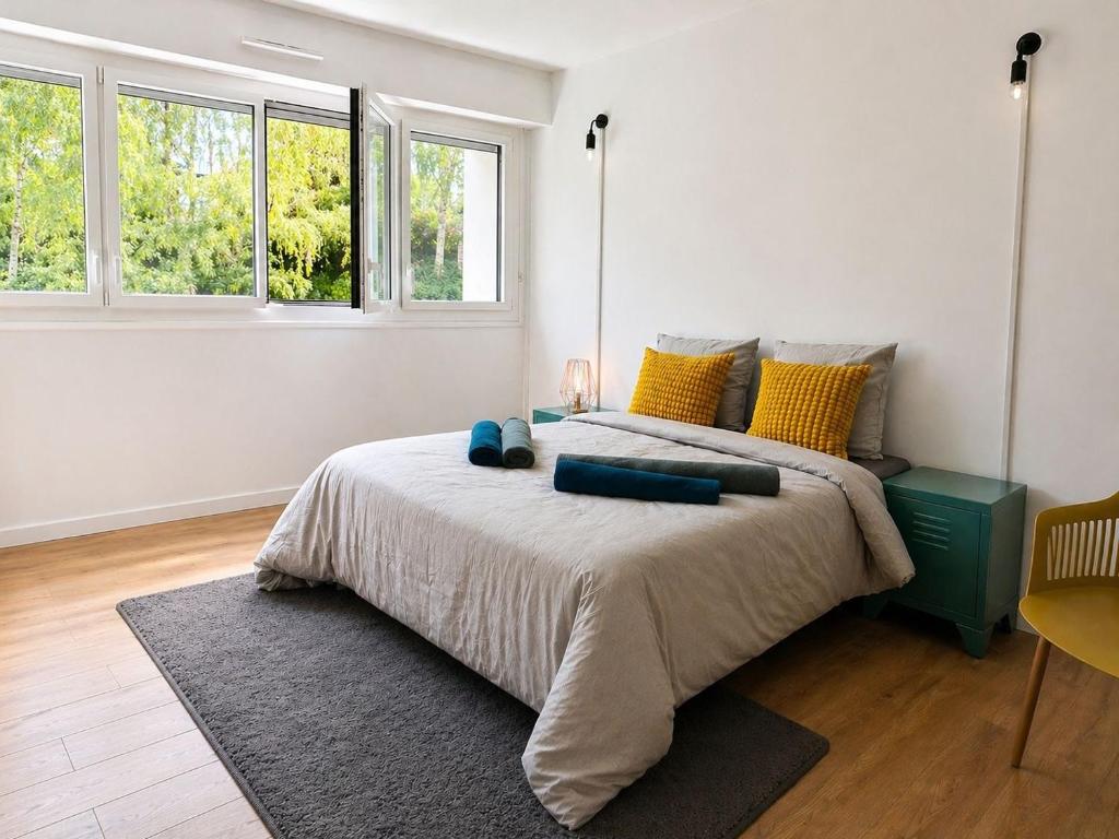 a bedroom with a large bed with yellow and blue pillows at Chambre privative Paris 13e in Paris