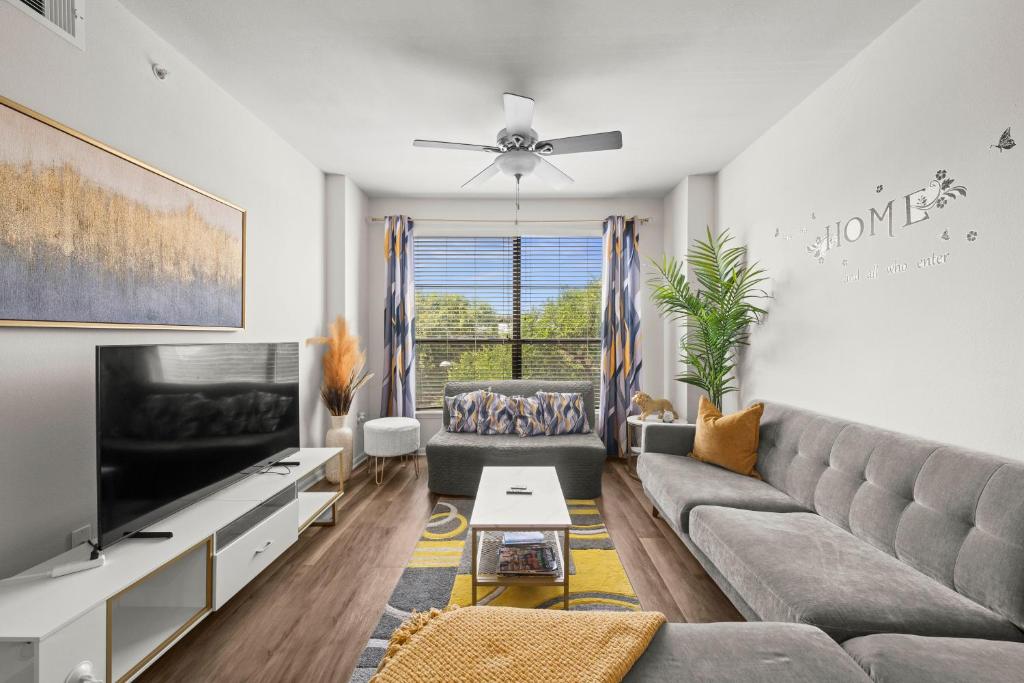 a living room with a couch and a tv at Spacious Blessed HOME for blessed guests at the Domain in Austin