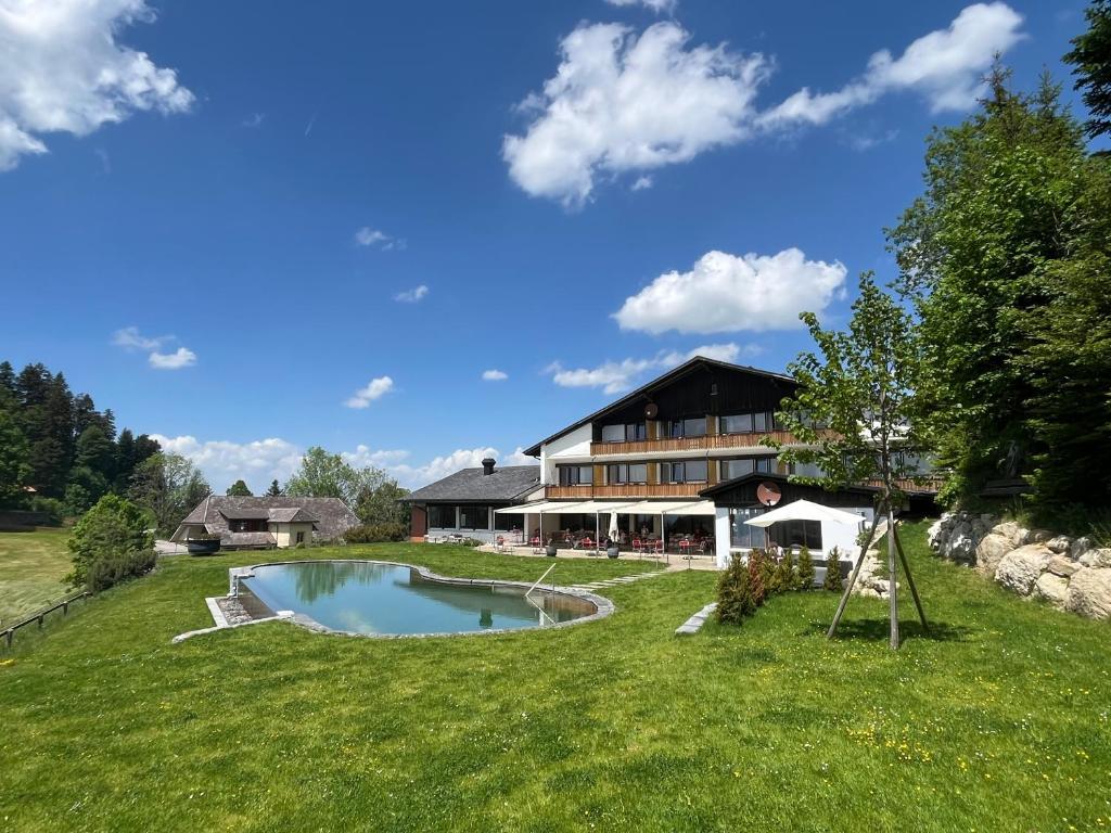 a house with a swimming pool in the yard at Bärnsicht Panorama Hotel in Wasen