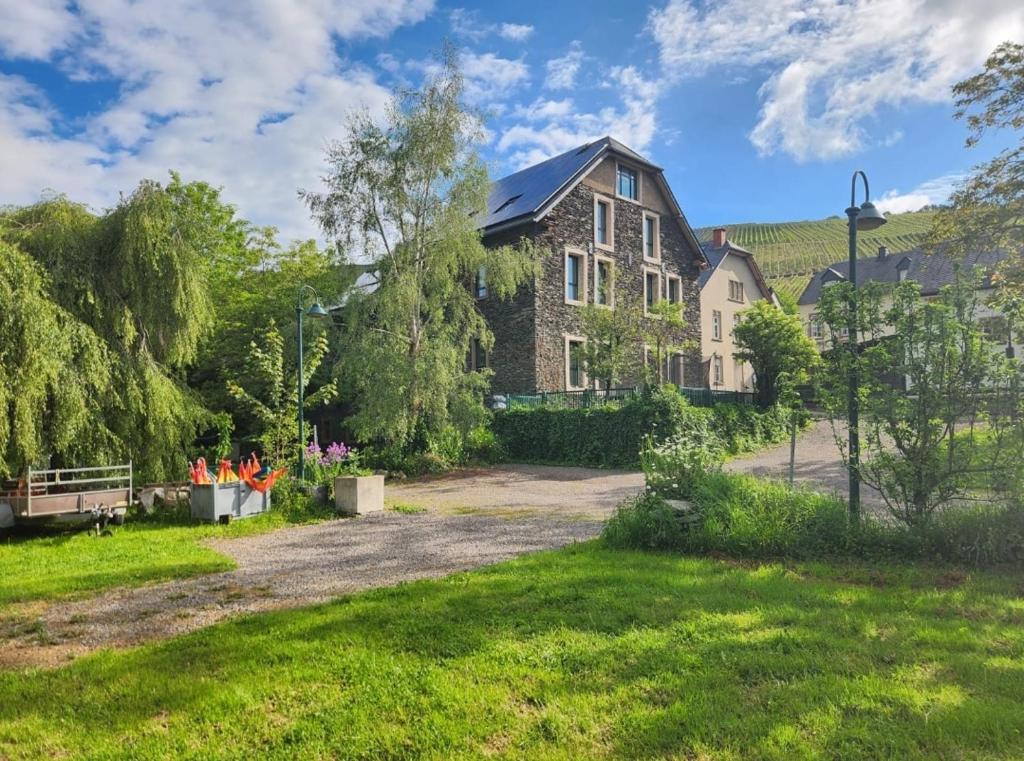 a large brick house with a green yard at Ferienwohnung Vital am Bach "Dhron" in Neumagen-Dhron