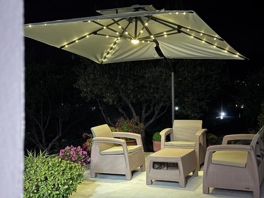 a group of chairs and an umbrella with lights at Villa Kalo in Blerimas