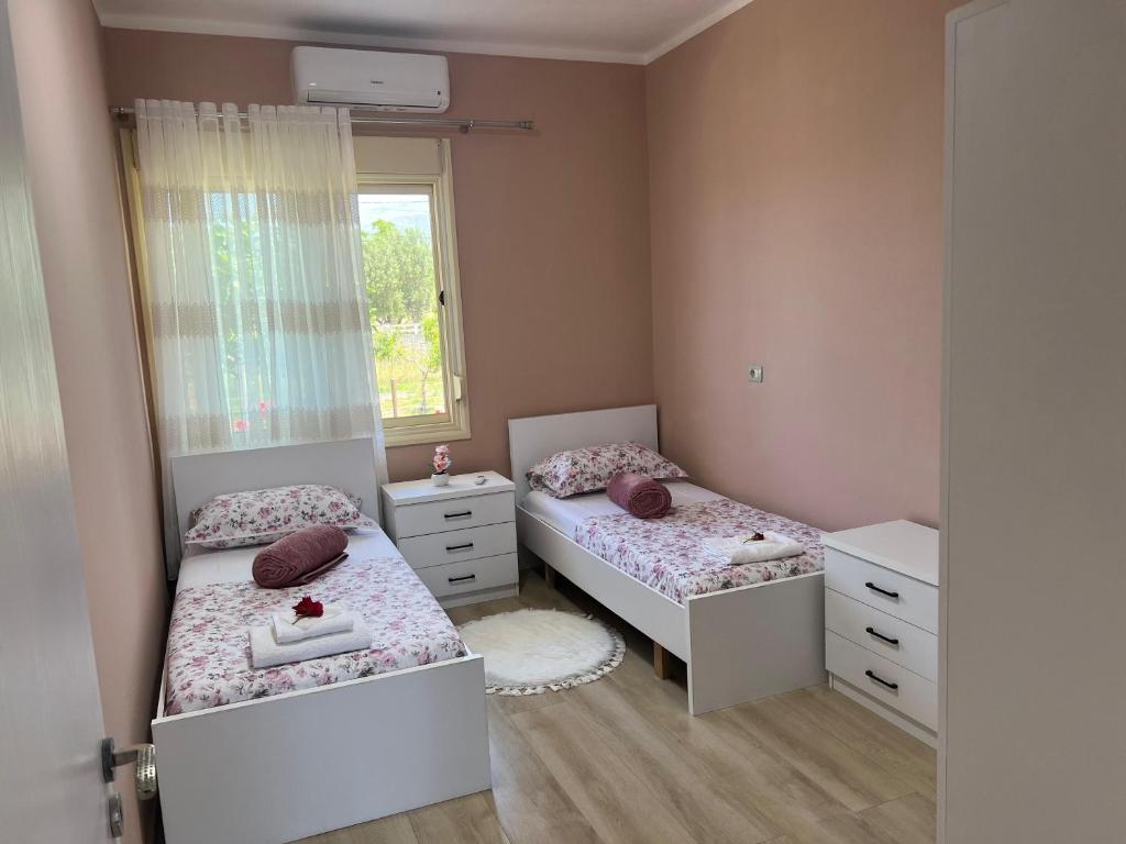 a bedroom with two beds and a window at Nesti house in Orikum