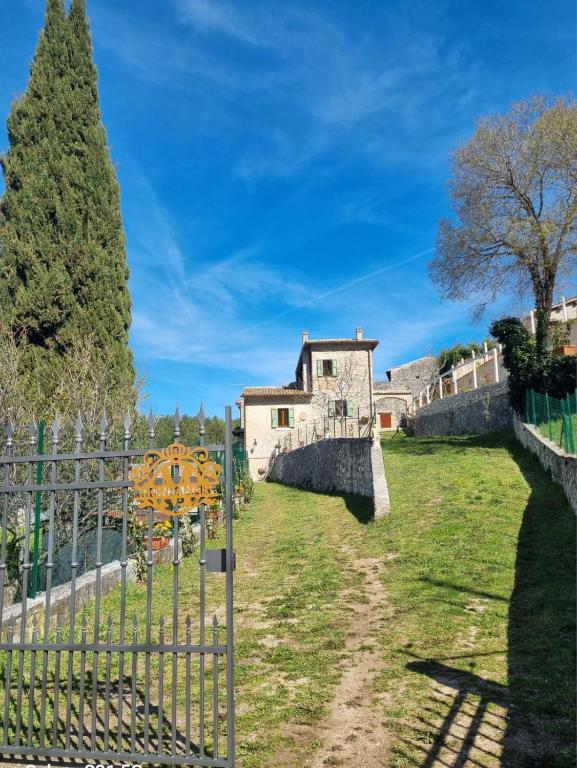 a fence in front of a building with a tree at Casale Montanari in Matigge