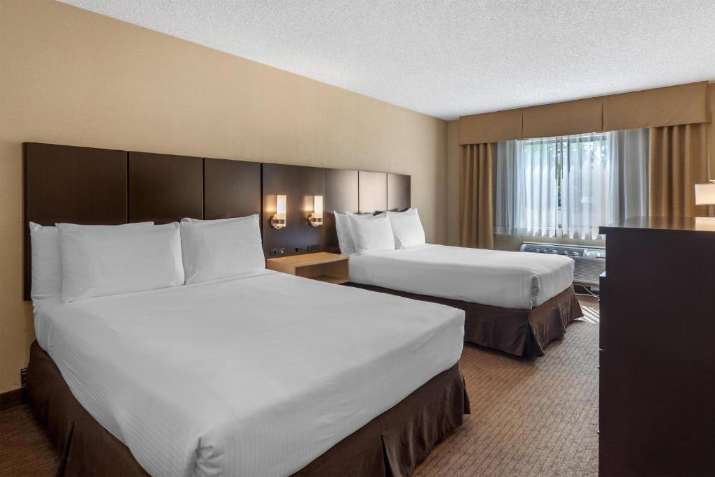 a hotel room with two beds and a television at Best Western Seattle Airport Hotel in SeaTac