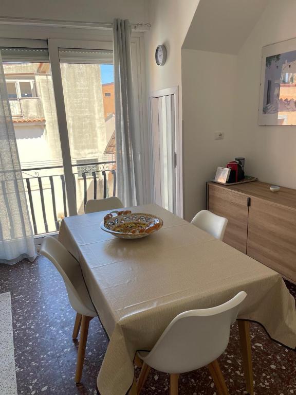a table with chairs and a bowl on top of it at Gemma's Apartments in Mazzeo