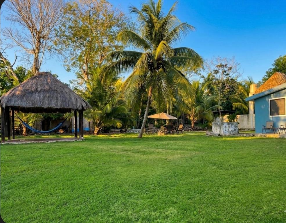 a yard with a gazebo and a palm tree at Villa Privada 1200m2 Laguna a Pasos Pet Friendly in Xul-Ha