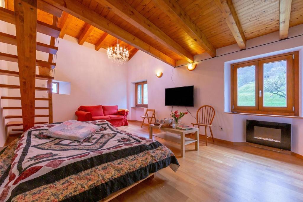 a bedroom with a bed and a living room with a fireplace at Casa Gialla Lake Lugano Townhouse for 5 - Happy Rentals in Pugerna