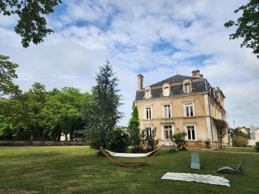 a hammock in front of a large house at Manoir, vaste parc arboré in Montbron