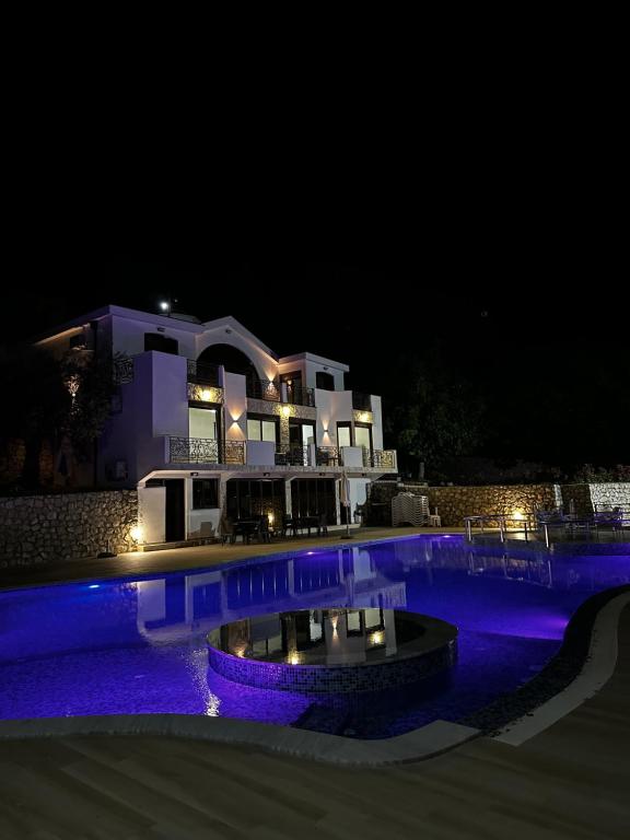 a night view of a house with a swimming pool at KAOM Lux in Dobra Voda