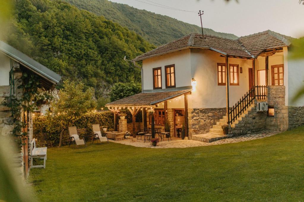 a house with a porch and a yard with grass at Kuća Mitića in Pirot