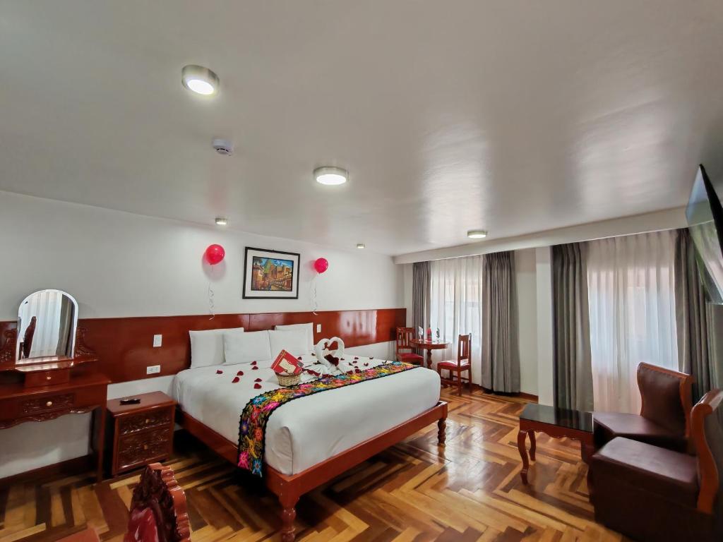 a hotel room with a large bed and a couch at Kantu hotel in Cusco
