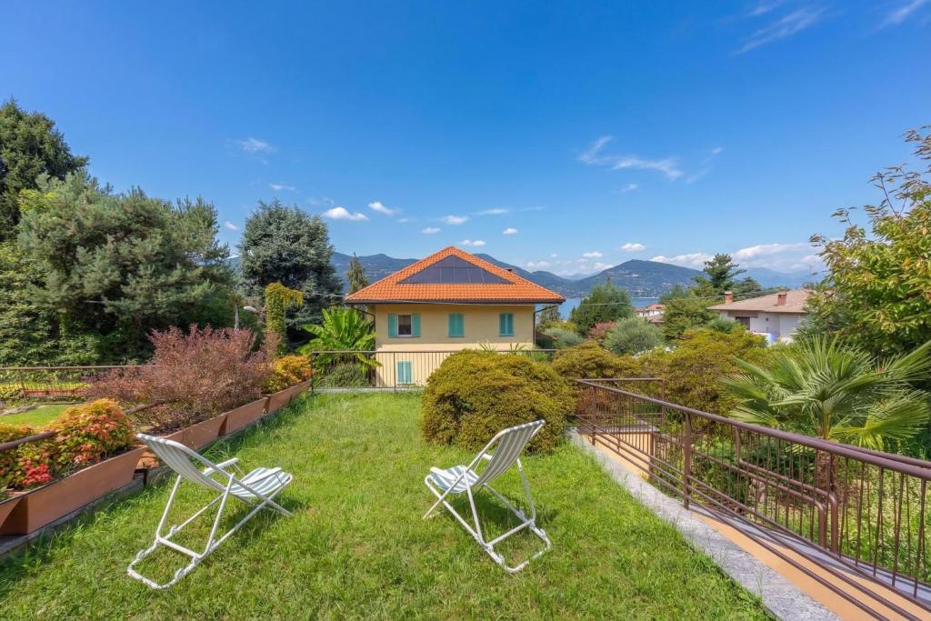 two chairs sitting on the grass in a yard at Sunset in Ranco: Lakeview Townhouse with Private Garden - Happy Rentals in Ranco