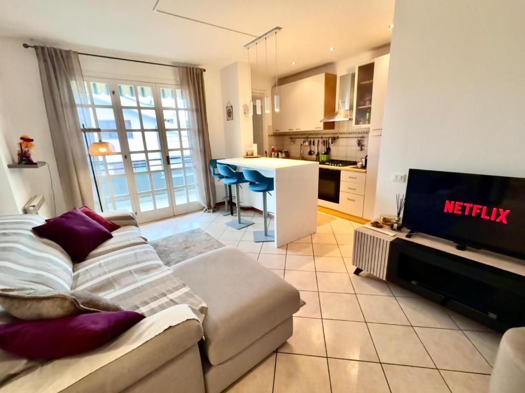 a living room with a couch and a tv and a kitchen at Casa di Minù in Empoli